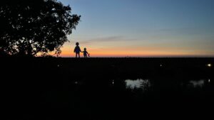 Bild von Sonnenuntergang und Erwachsener mit Kind - Gute Nacht Geschichte vorlesen